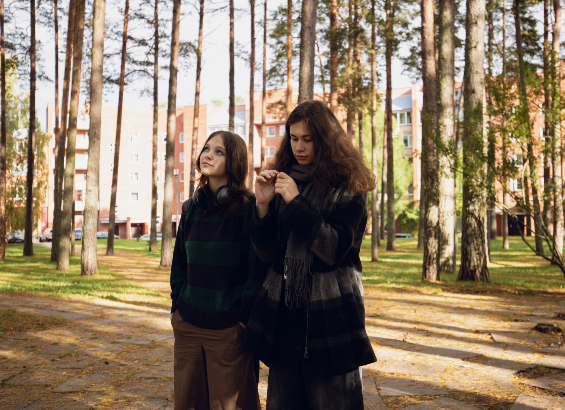 Two Film Camp participants standing among pine trees outdoors in autumn